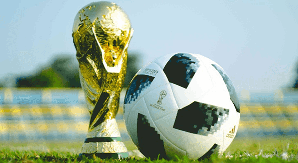 World Cup trophy and football on the pitch